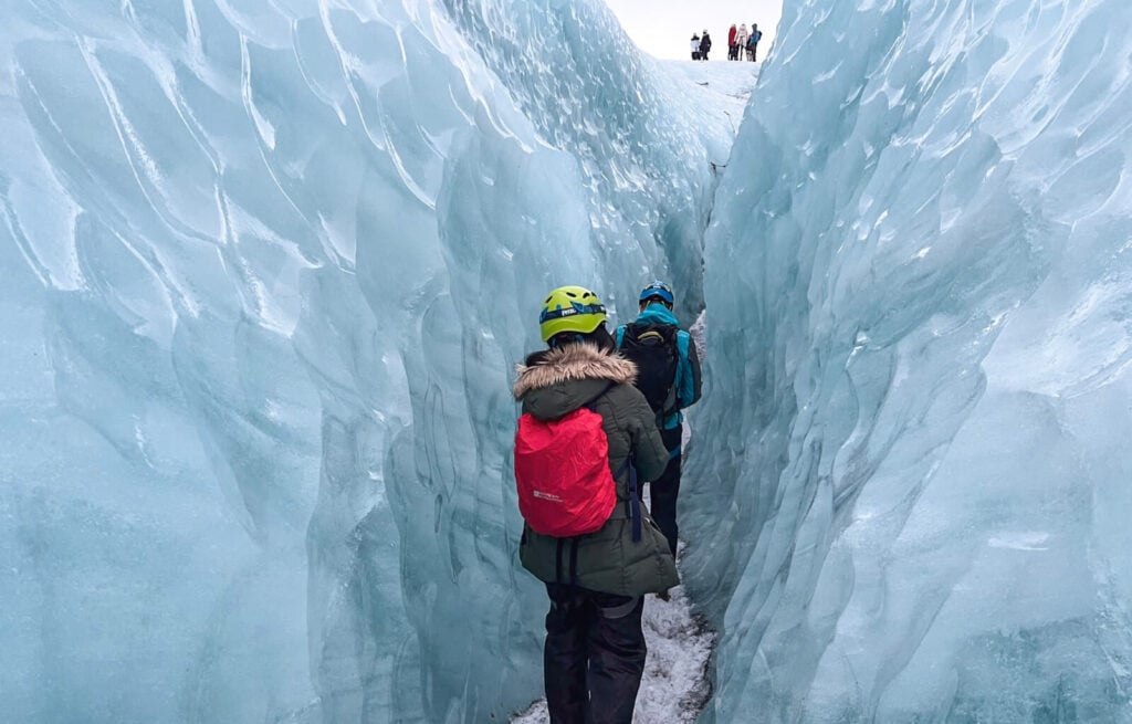Walking between a glacier tunnel during our glacier hike