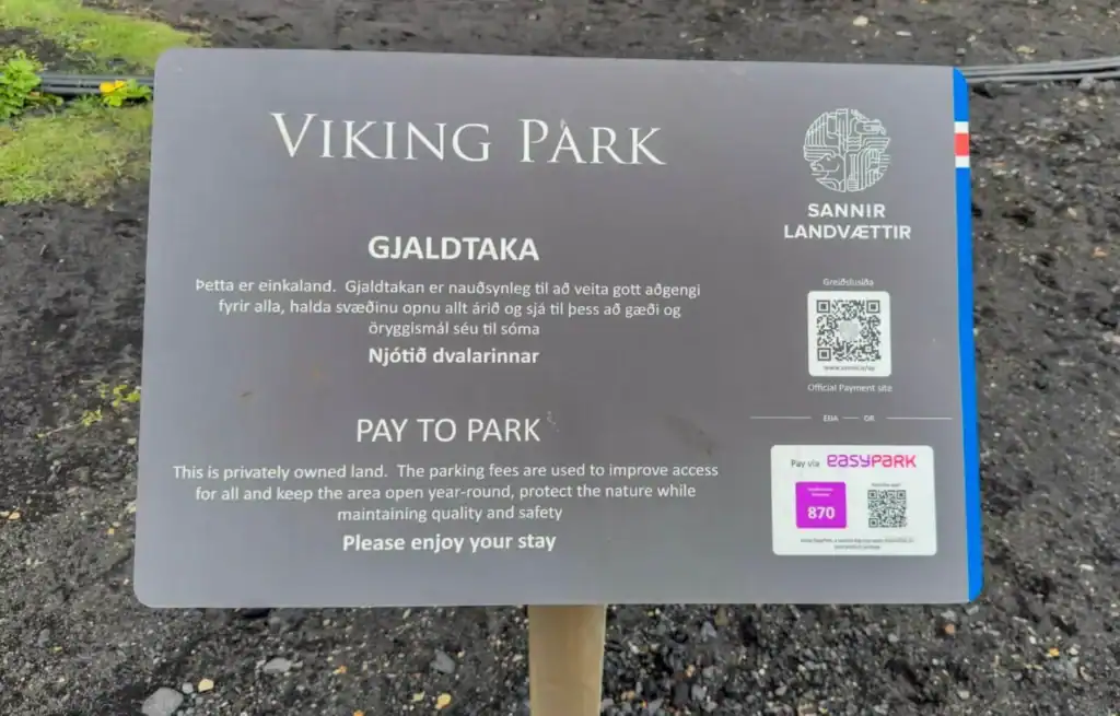 Viking Park pay to park sign with QR code and parking fee details in Icelandic and English.