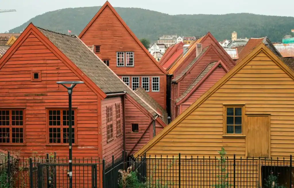 Colourful wooden houses in Bergen, Norway, with mountains in the background.