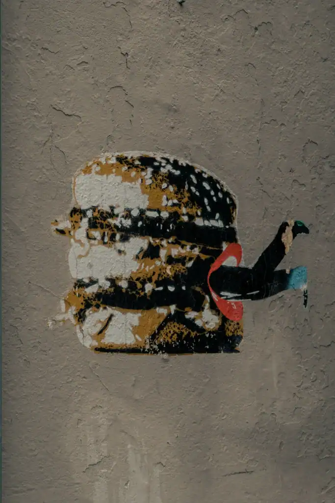 Street art graffiti of a person with a swan on their head, painted on a textured wall.