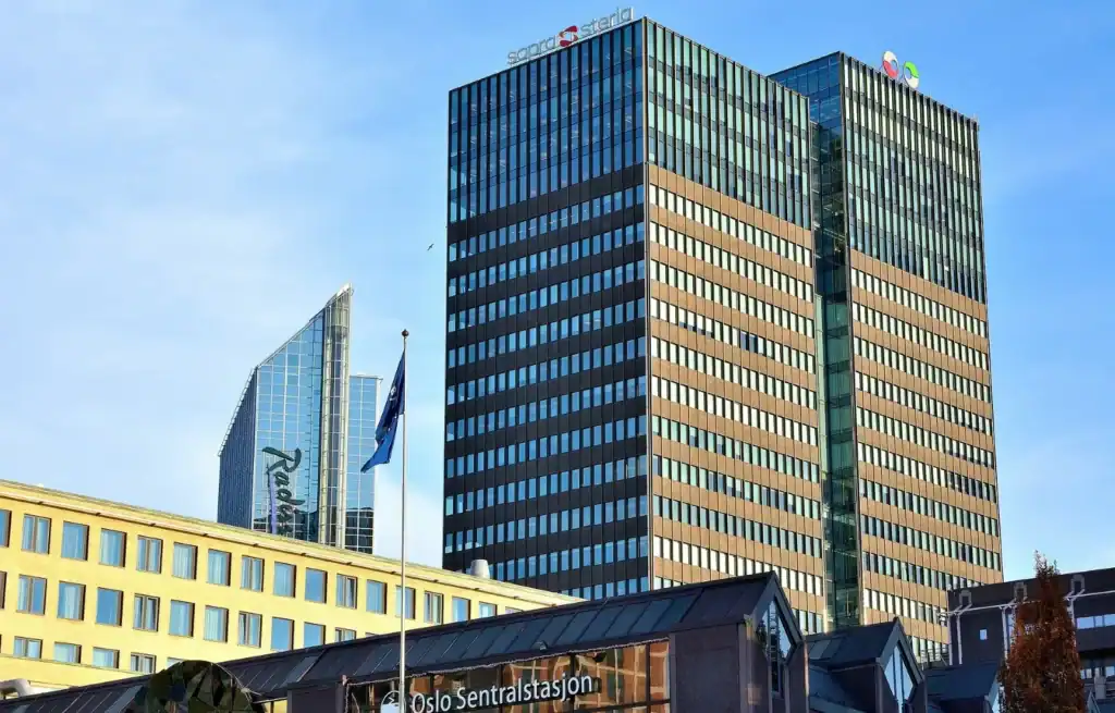 Sentral Station in Oslo with a hotel in the foreground and a second hotel, a Radisson, in the distance